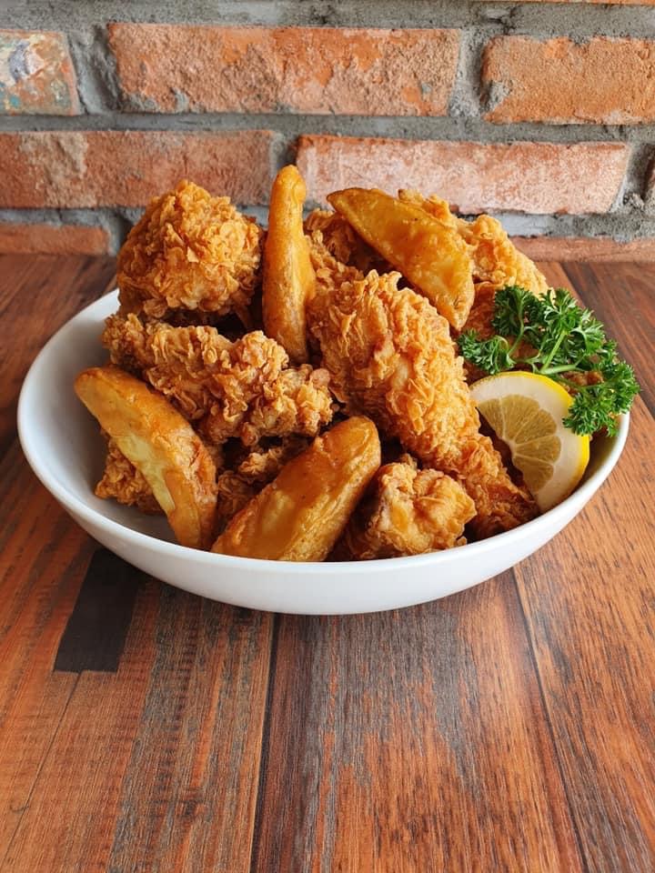 A bowl of Papas Chicken crispy fried chicken with potato wedges